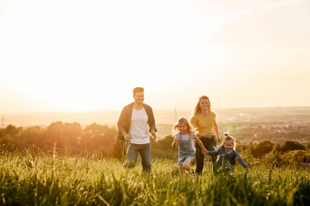 Eine Familie die auf einer Wiese läuft