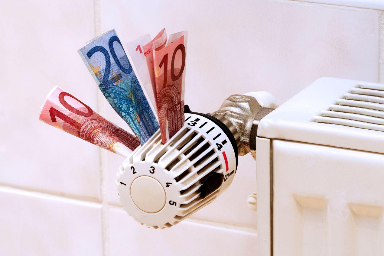 Geldscheine im Heizkörper-Thermostat als Symbol für steigende Heizölpreise in Hamburg