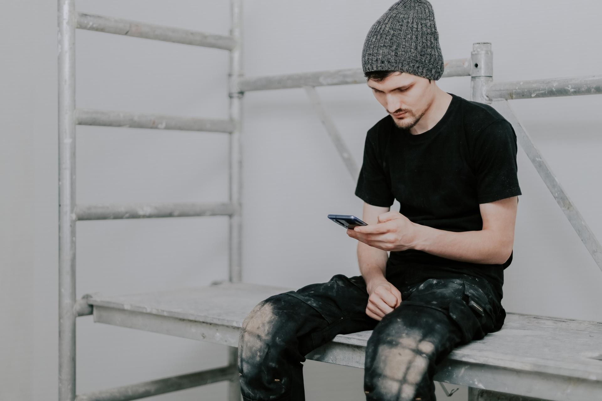Handwerker macht Pause mit Smartphone | Elf Bar 600 kaufen